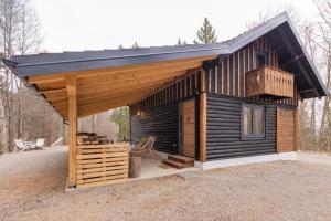 a large wooden cabin with a gambrel roof at Srčkova Koča in Kočevje +26 photos