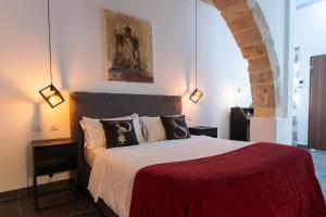 a bedroom with a large bed with a red blanket at Pjazza Suites Boutique Hotel by CX Collection in Siġġiewi +190 photos