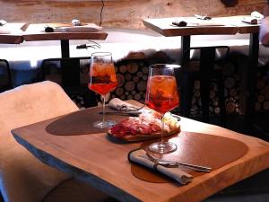 a table with two wine glasses and a plate of food at Green Hospitality Monolocale Stella Alpina in Livigno