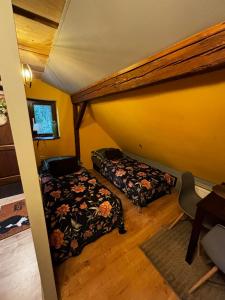 a attic room with a bed and a bed at Šumava apartmán U Kočiček in Strašice