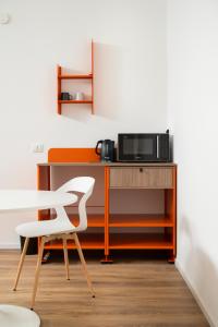 a desk with a microwave and a white chair at Ospitalità Il Prato in Iesi