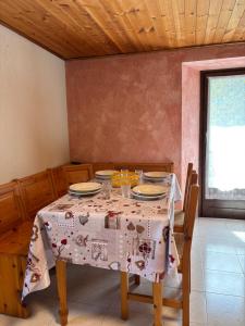 a table with plates and glasses on it in a room at Casa parrocchiale La Salle in La Salle