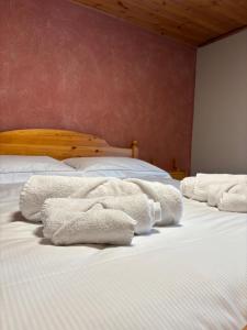two white towels sitting on top of a bed at Casa parrocchiale La Salle in La Salle +4 photos