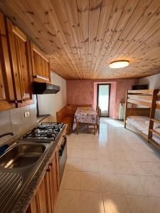 a kitchen with a stove and a bunk bed at Casa parrocchiale La Salle in La Salle