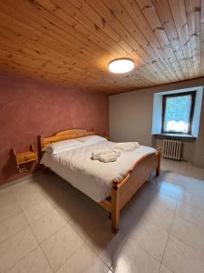 a bedroom with a large bed with a wooden ceiling at Casa parrocchiale La Salle in La Salle
