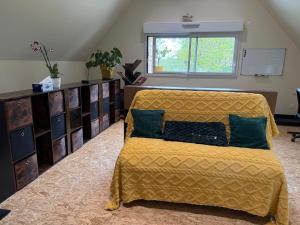a bedroom with a bed with a yellow bedspread at Le Studio d'Instant Nature in Alexain