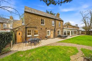 an exterior view of a brick house with a patio at Lee's Historic Mansion in Cheshunt