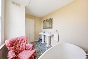 a bathroom with a chair and a sink at Lee's Historic Mansion in Cheshunt +66 photos