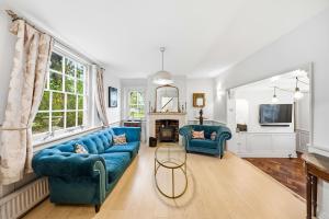 a living room with two blue couches and a fireplace at Lee's Historic Mansion in Cheshunt