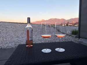 a bottle of wine and two glasses on a table at Studio mit Alpenblick und privaten Terrasse in Kleinweil