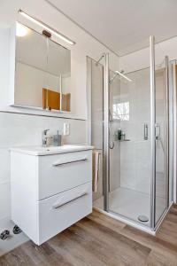 a white bathroom with a shower and a sink at Knusthof Lafrenz - Küstenblick in Fehmarn