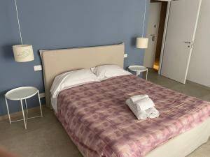 a bedroom with a large bed with two stools at Hotel Miramare in Savona