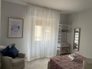 a bedroom with a bed and a chair and a window at Hotel Miramare in Savona