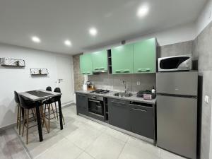 a kitchen with green cabinets and a stainless steel refrigerator at Apartman Lari in Vižinada