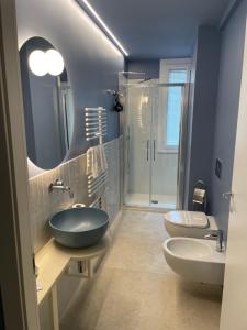 a bathroom with two sinks and a tub and a shower at Hotel Miramare in Savona