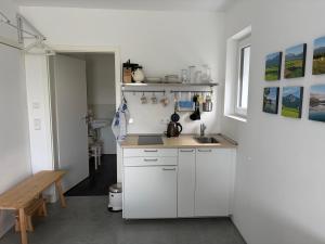 a kitchen with white cabinets and a sink at Studio mit Alpenblick und privaten Terrasse in Kleinweil