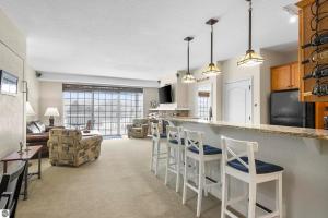 a kitchen and living room with a bar with stools at Bird's Eye View at Hawk's Eye in Bellaire