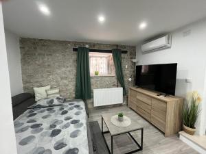 a living room with a bed and a flat screen tv at Apartman Lari in Vižinada
