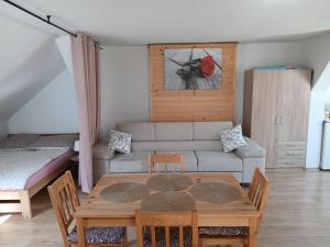a living room with a table and a couch at Agroturystyka pod kasztanem in Lutowiska