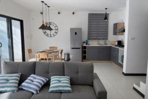 a living room with a couch and a kitchen at Chalet des Roses in Grand-Baie
