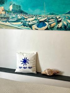 a pillow sitting on a shelf next to a painting of boats at Marea L in Lerici