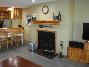 a living room with a fireplace and a dining room at No Worries at Summit Village! in Bellaire