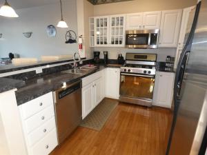 a kitchen with white cabinets and a stainless steel refrigerator at Skier's Slopeside Haven in Bellaire +41 photos