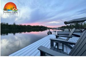 a dock with tables and chairs on a lake at Driftwood on Torch River in Rapid City