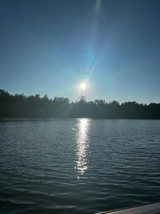 a lake with the sun shining on the water at Driftwood on Torch River in Rapid City