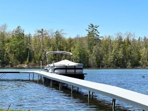a boat is docked at a dock on a lake at Driftwood on Torch River in Rapid City +43 photos