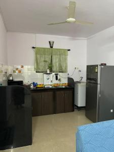 a kitchen with a refrigerator and a counter top at Apartmentbyzaara in Colva