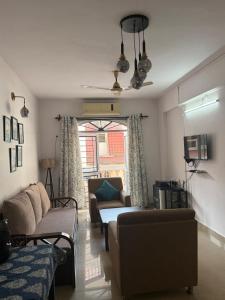 a living room with a couch and a chair at Apartmentbyzaara in Colva