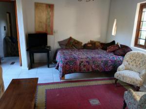 a bedroom with a bed and a chair and a table at Natalie's Garden Cottage, in McGregor