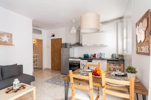a kitchen and living room with a wooden table and chairs at CHiC APARTMENT in Tossa de Mar