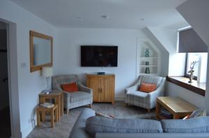a living room with two chairs and a couch at Ness View Apartment in Inverness