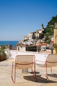 a couple of chairs sitting on top of a building at AmalfiRa Luxury Seaview Rooftop in Amalfi