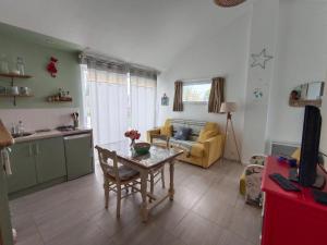 a kitchen and living room with a table and a couch at le Pressoir Doretz in Arthon-en-Retz