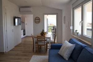 a living room with a blue couch and a table at GUESTHOUSE Kastel Novi in Kaštela