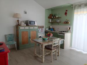 a kitchen with a table and chairs and a kitchen with green walls at le Pressoir Doretz in Arthon-en-Retz