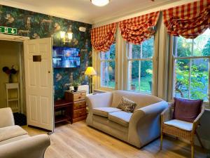a living room with a couch and chairs and windows at Pickwicks Guest House in Oxford