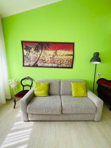 a living room with a couch and a green wall at Xerxe's House in Varenna