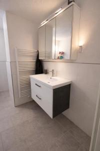 a white bathroom with a sink and a mirror at Ferienwohnung Wald-Michelbach in Wald-Michelbach +13 photos