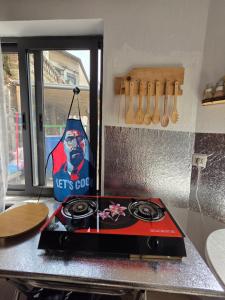 a stove top in a kitchen with a sign on it at Green Door Hostel in Tirana +21 photos