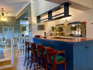 a bar with stools in a kitchen with a counter at Pickwicks Guest House in Oxford