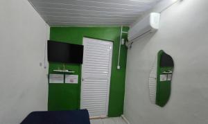 a room with green and white walls and a door at Quarto solteiro custo-benefício in São Luís +7 photos