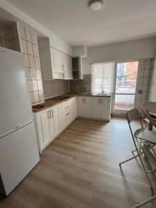 a kitchen with white cabinets and a white refrigerator at O Repouso in Lalín