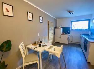 a living room with a table and chairs and a kitchen at Weiher Apartment mit Terrasse & Parkplatz in Kulmbach