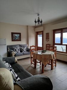 a living room with a couch and a table and chairs at Apartamentos Turísticos Rural Los Tinaos in Bubión