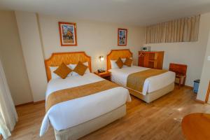a hotel room with two beds and a table at Sol Plaza Hotel in Puno +137 photos