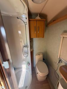 a small bathroom with a toilet and a shower at Little hideaway in Costa da Caparica